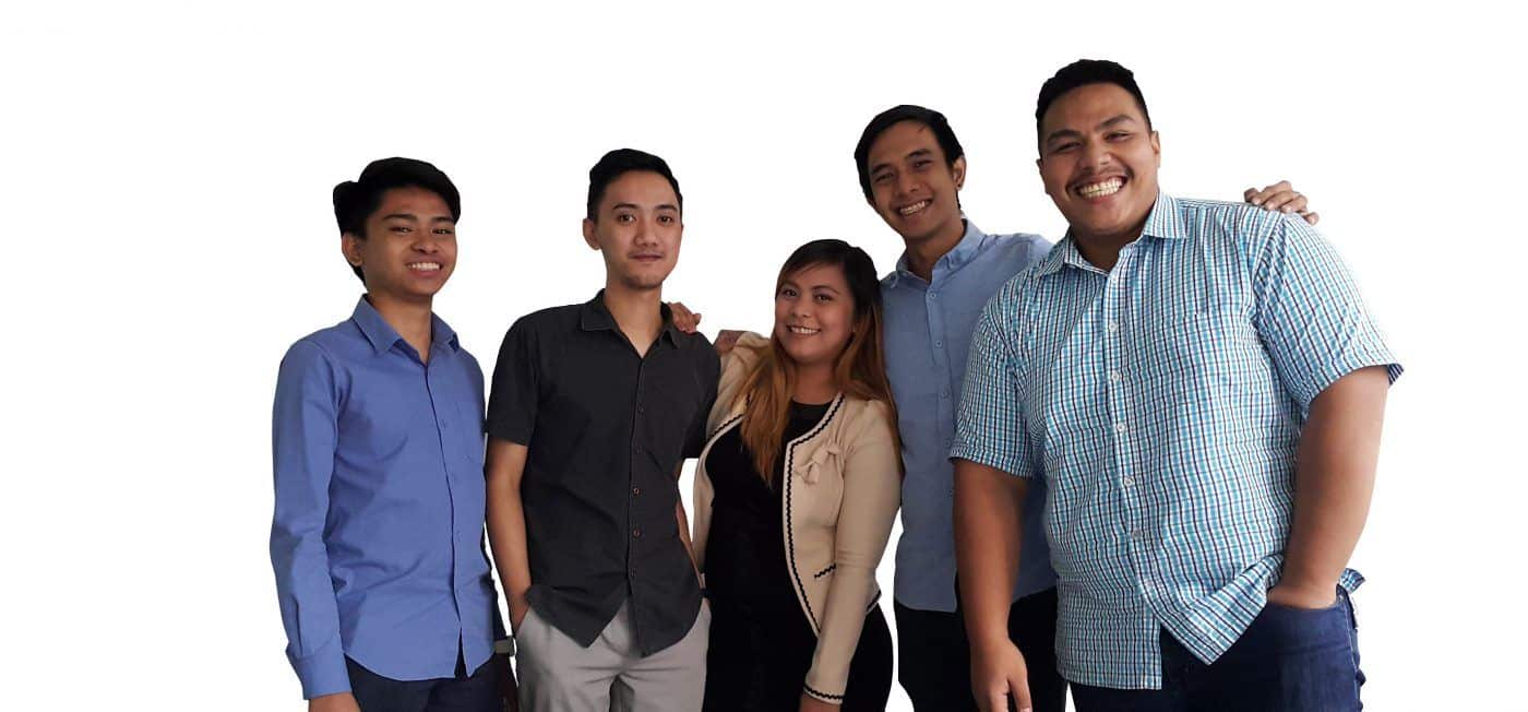 Five colleagues standing together and smiling at the camera