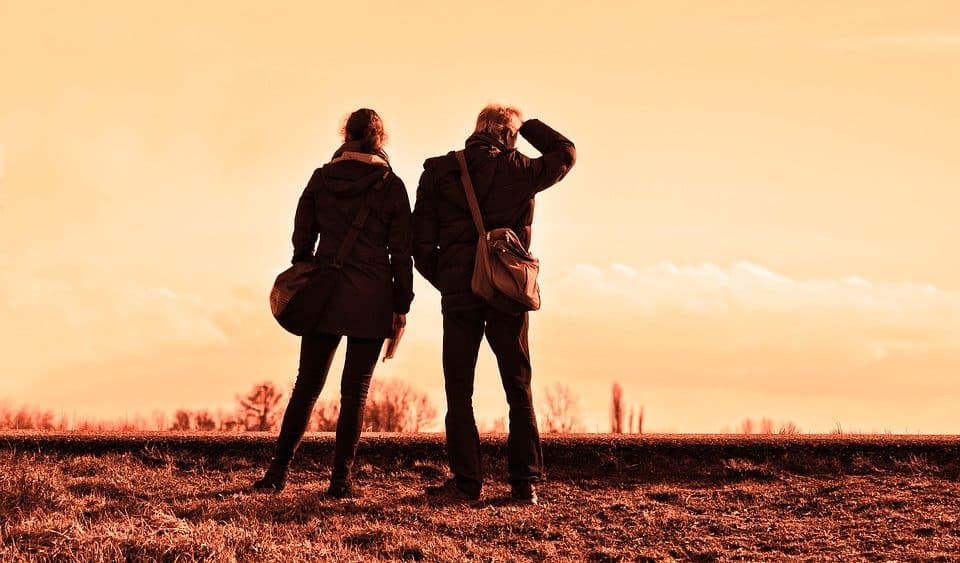 Two individuals are standing at the side of the road.