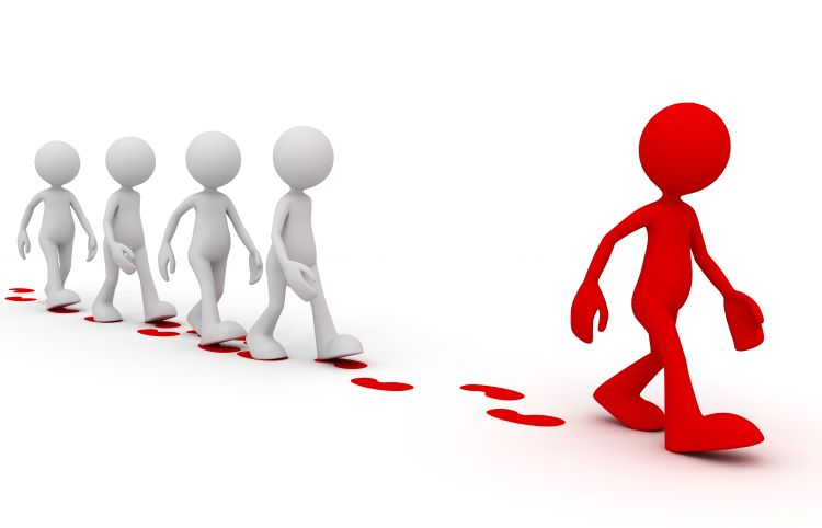 red humanlike figure walking ahead of white human-like figures