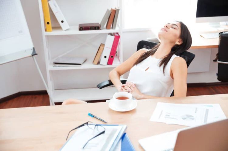 woman taking a nap in front of her work desk