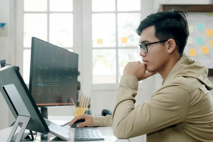 male employee with glasses focused on his laptop screen