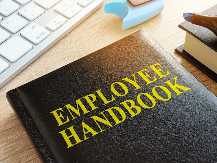 Employee Handbook On A Wooden Desk In Office.