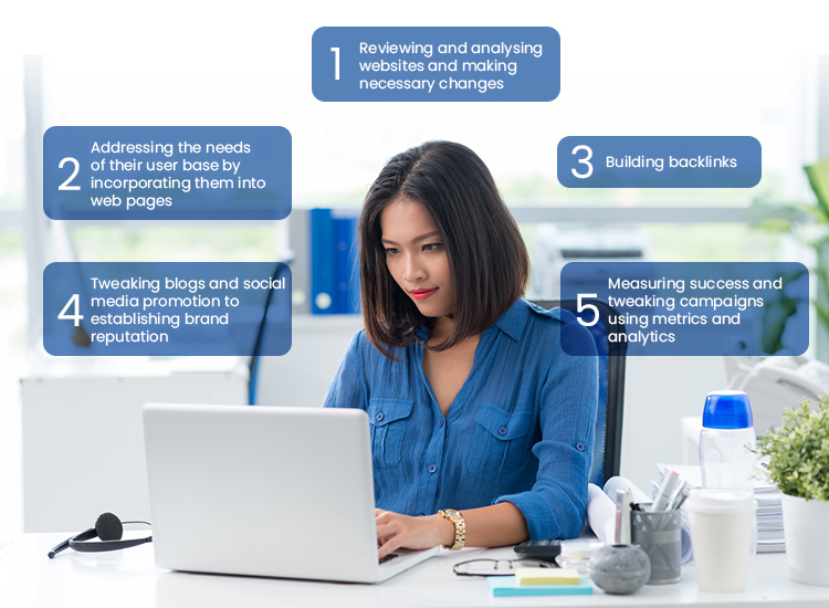 Woman in blue typing on her laptop