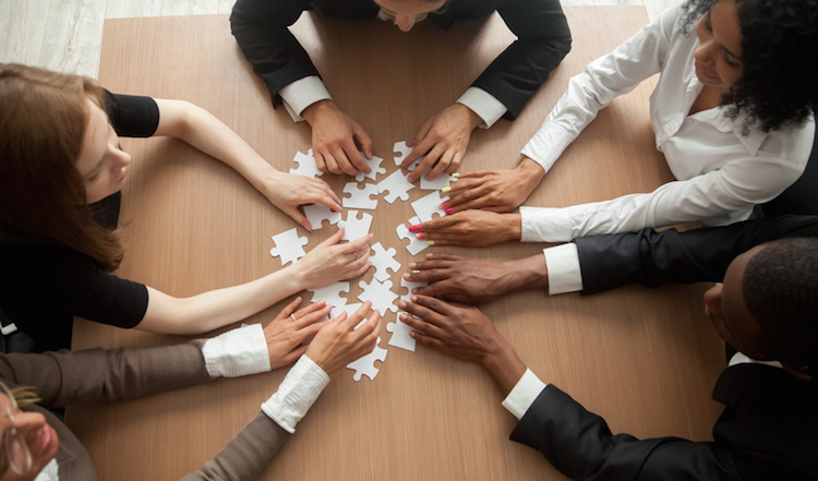 a team of people putting together puzzle pieces