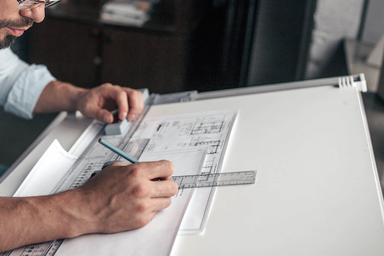 a man drawing a blueprint