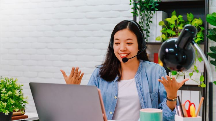 woman wearing a headset and speaking to someone online