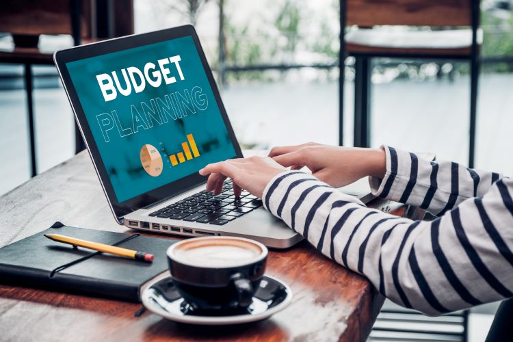 man typing budget planning on his laptop