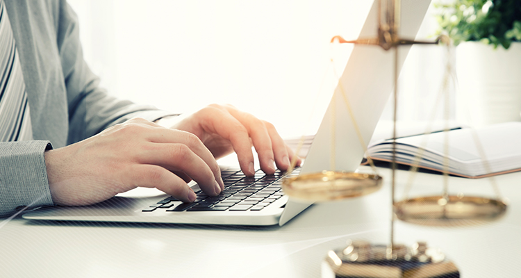 woman using her laptop, scales of justice shown