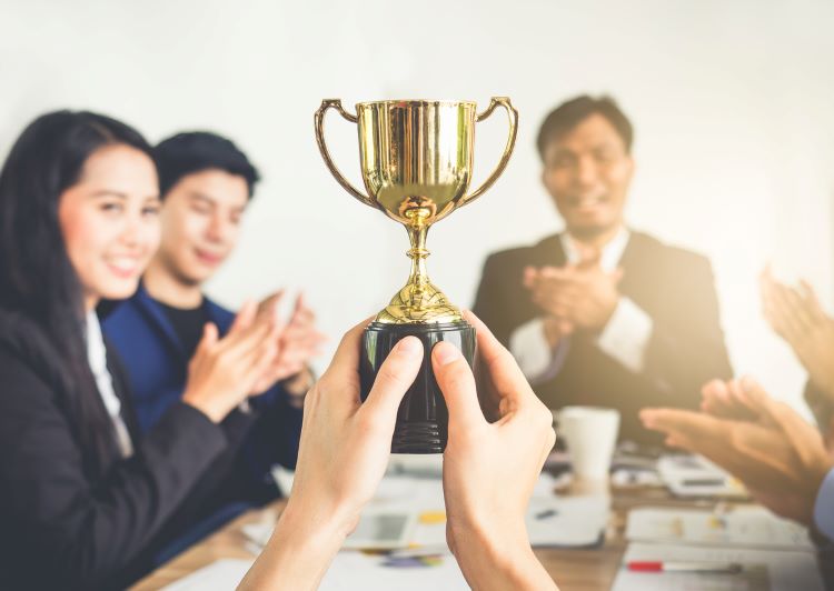 trophy with people clapping in the background