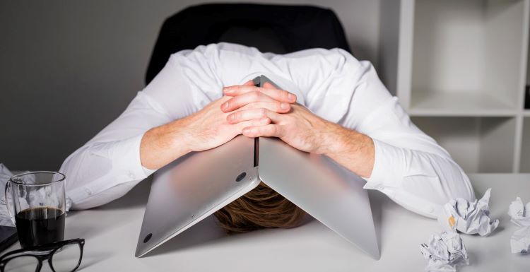 man with his laptop over the back of his head