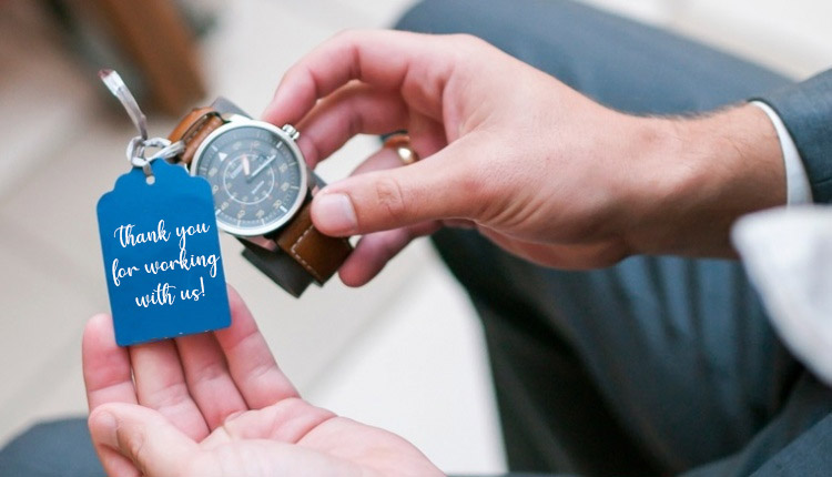 a man holding a watch with a blue tag