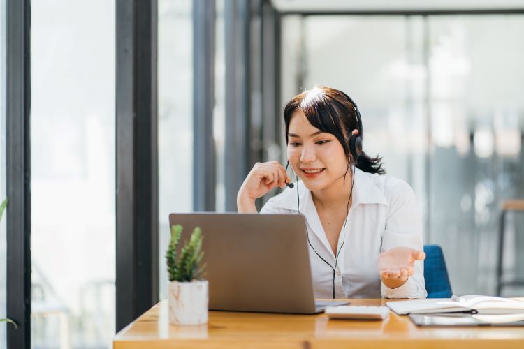 A woman wearing a headset and talking to someone online